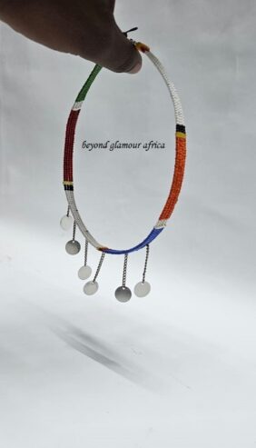 A small blue and white neck choker with silver daggling decorations
